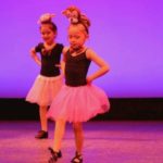 two girls dancing on stage